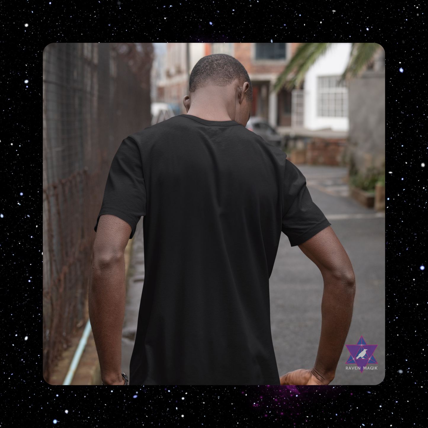 Man wearing a black t-shirt walking away on a street.