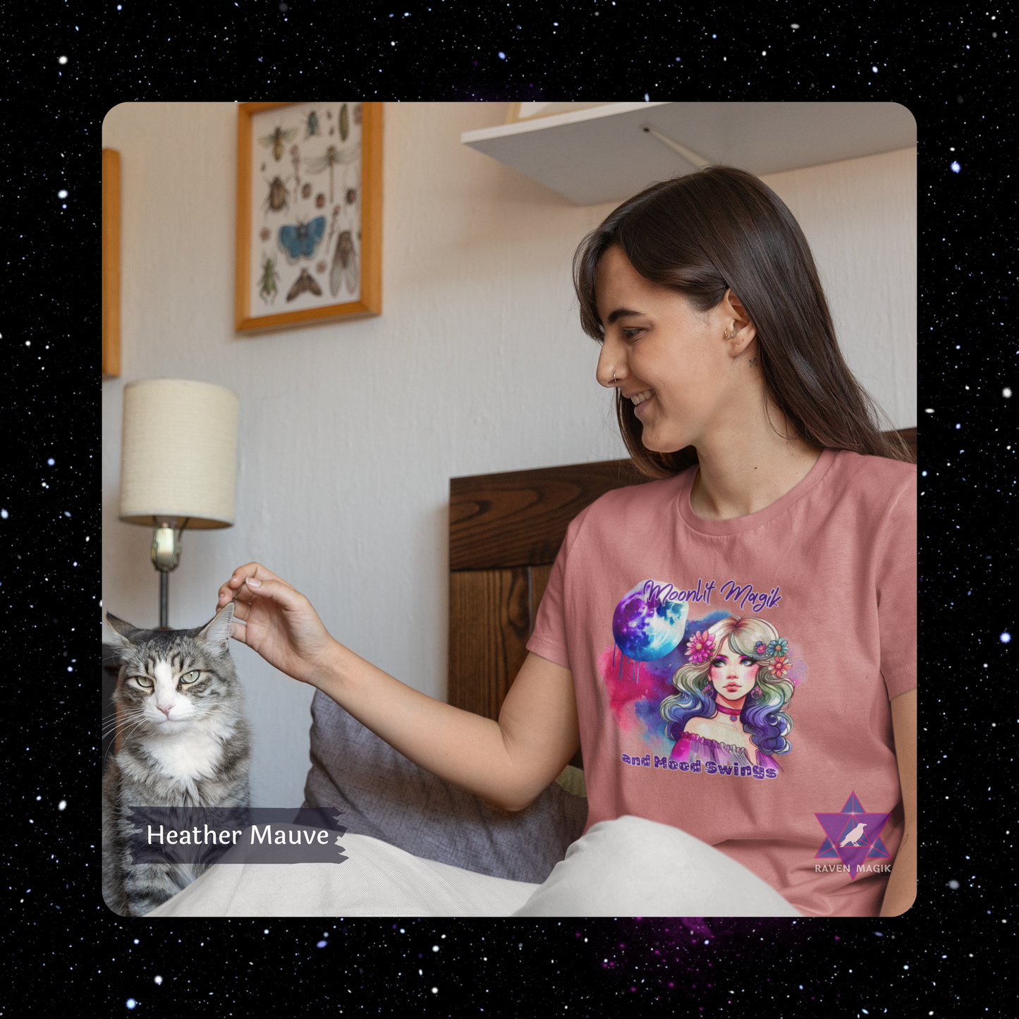 Woman wearing a pink t-shirt with a colorful graphic design, sitting next to a cat. Cancer Zodiac T-shirt with “Moonlit Magik and Mood Swings” slogan, styled for intuitive, emotional energy.