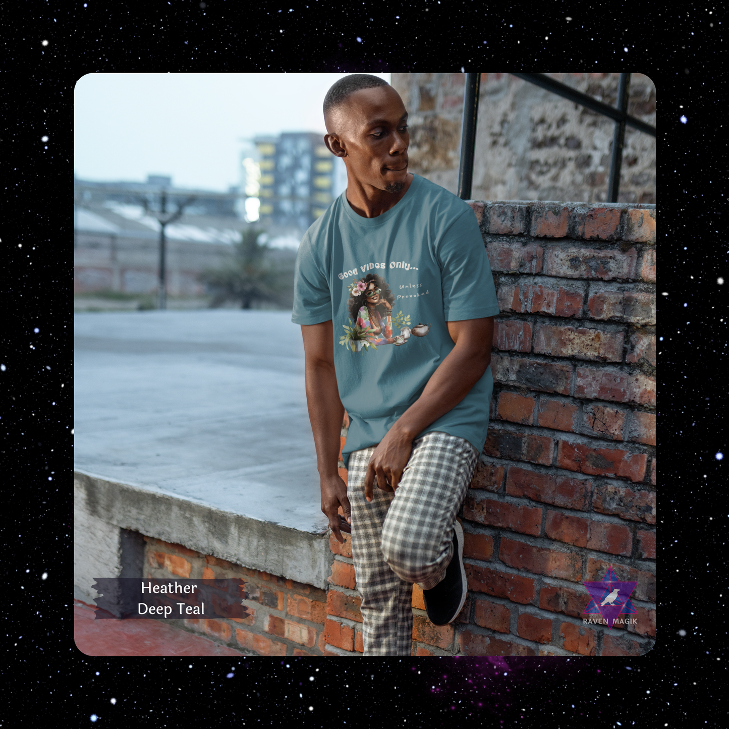 Man wearing a teal t-shirt leaning against a brick wall with a cityscape background. Gemini Archetype T-shirt with “Good Vibes Only… Unless Provoked” slogan, styled for expressive, unpredictable energy and dual-natured charm.