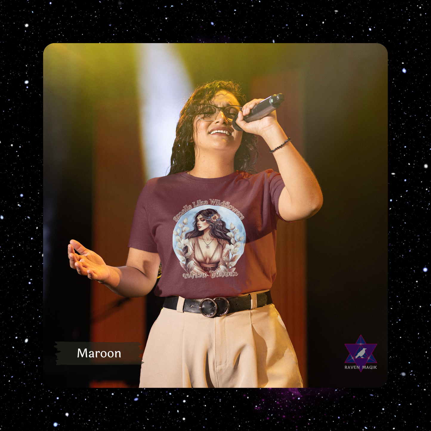 Person wearing a maroon t-shirt with a graphic design, holding a microphone on a dark background. Taurus Archetype T-shirt with “Smells Like Wildflowers and Low Tolerance” slogan, styled for grounded, sensual energy and earthy elegance.