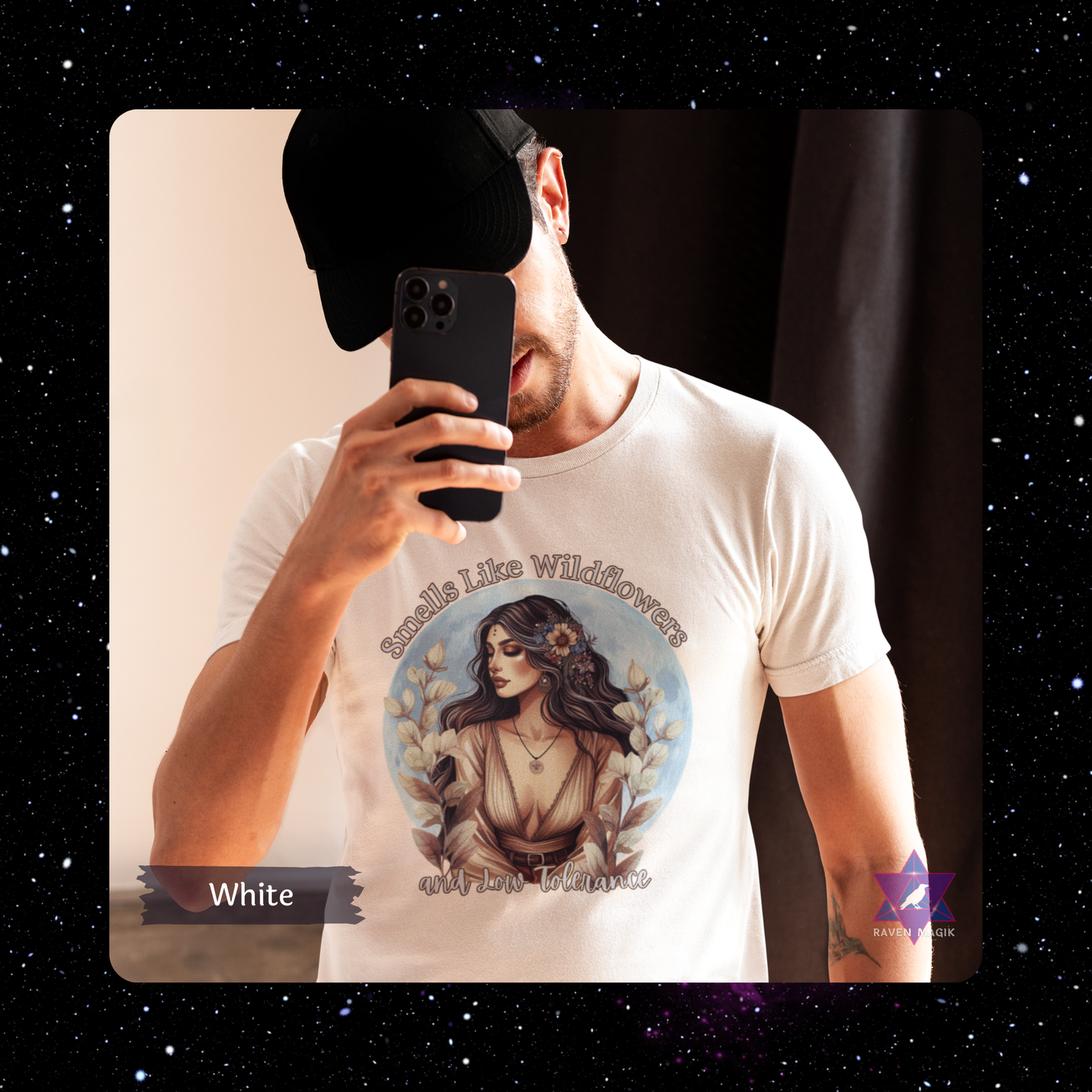 Person wearing a white t-shirt with a graphic design and text, holding a phone. Taurus Archetype T-shirt with “Smells Like Wildflowers and Low Tolerance” slogan, styled for grounded, sensual energy and earthy elegance.