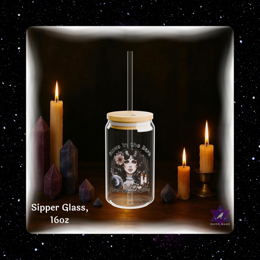 Glass sipper jar with wooden lid on a dark background with candles and crystals