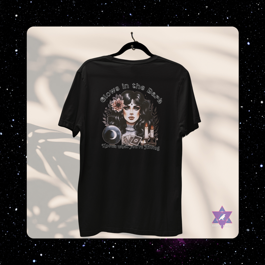 Black t-shirt with graphic design on a hanger against a white background. Scorpio Archetype T-shirt with “Glows in the Dark and Knows What You’re Hiding” slogan, styled for mysterious, magnetic energy and shadowy charm.