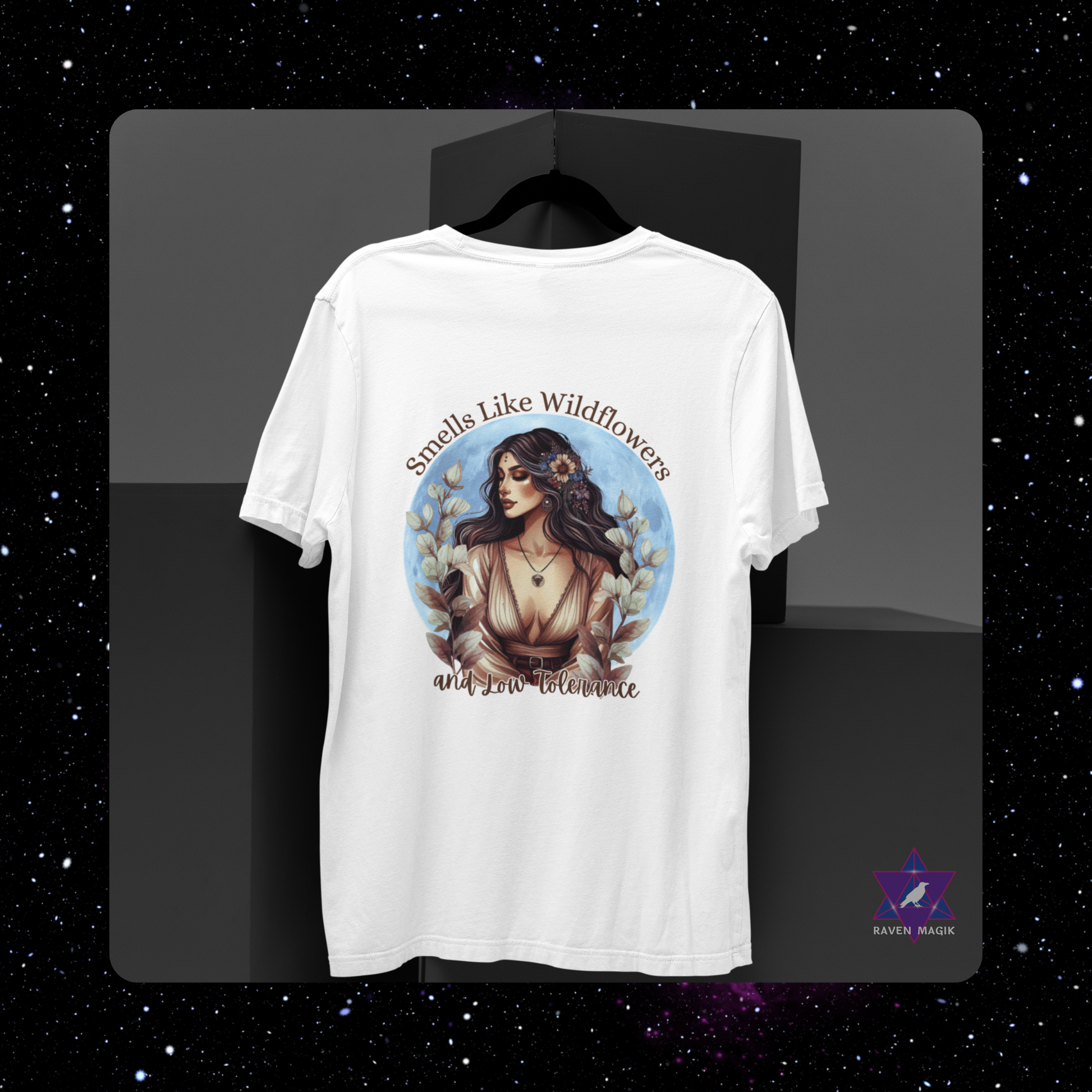 White t-shirt with a graphic design of a woman and text 'Smells Like Wildflowers and Low Toleration' on a dark background.